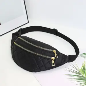Schwarze gesteppte Bauchtasche mit goldenen Reißverschlüssen auf hellem Hintergrund