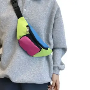 Neonfarbene Bauchtasche in Blau, Grün und Pink, quer über dem grauen Pullover getragen