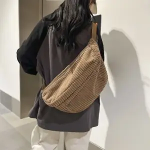 Frau trägt eine hellbraune Cord-Bauchtasche schräg über dem Rücken, Rückansicht