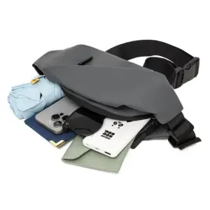Graue Bauchtasche aus mattem Material mit schwarzem Gurt und Inhalt wie Handy und Regenschirm