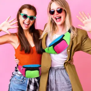 Neonfarbene Retro-Bauchtasche in Pink, Grün und Blau, von einer Frau vor dem Körper getragen