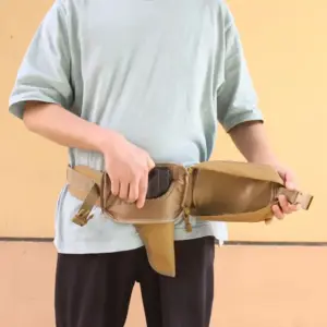 Sandbraune Bauchtasche, von einer Person im hellblauen Shirt vor dem Körper gehalten